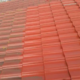 Częściowo wyczyszczony, czerwony dach z dachówki ceramicznej, widoczna różnica między brudną, porośniętą mchem powierzchnią a czystą, umytą częścią dachu.