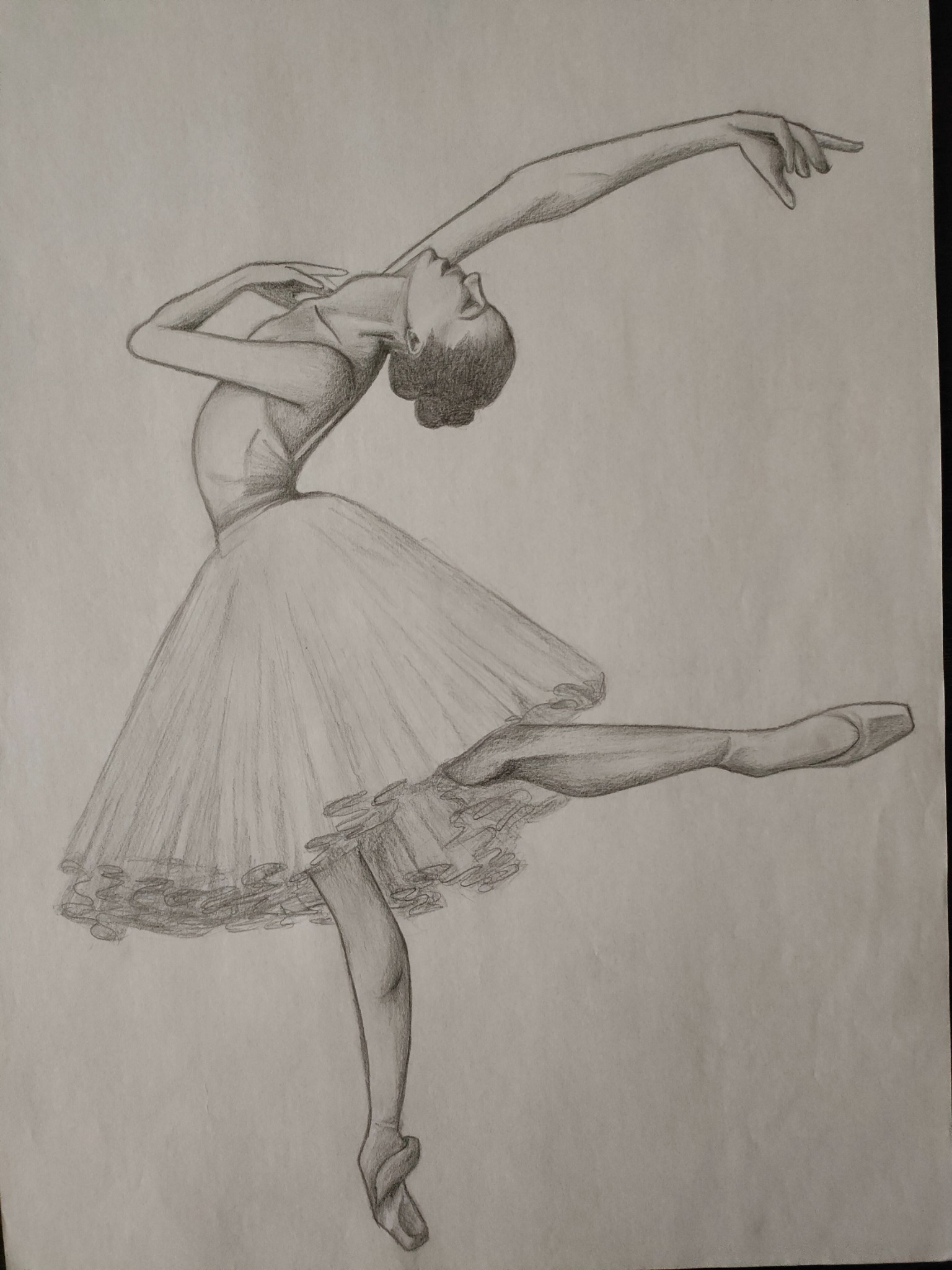 Szkic ołówkiem przedstawiający baletnicę w dynamicznej pozie, z uniesioną ręką i nogą, na białym tle papieru.