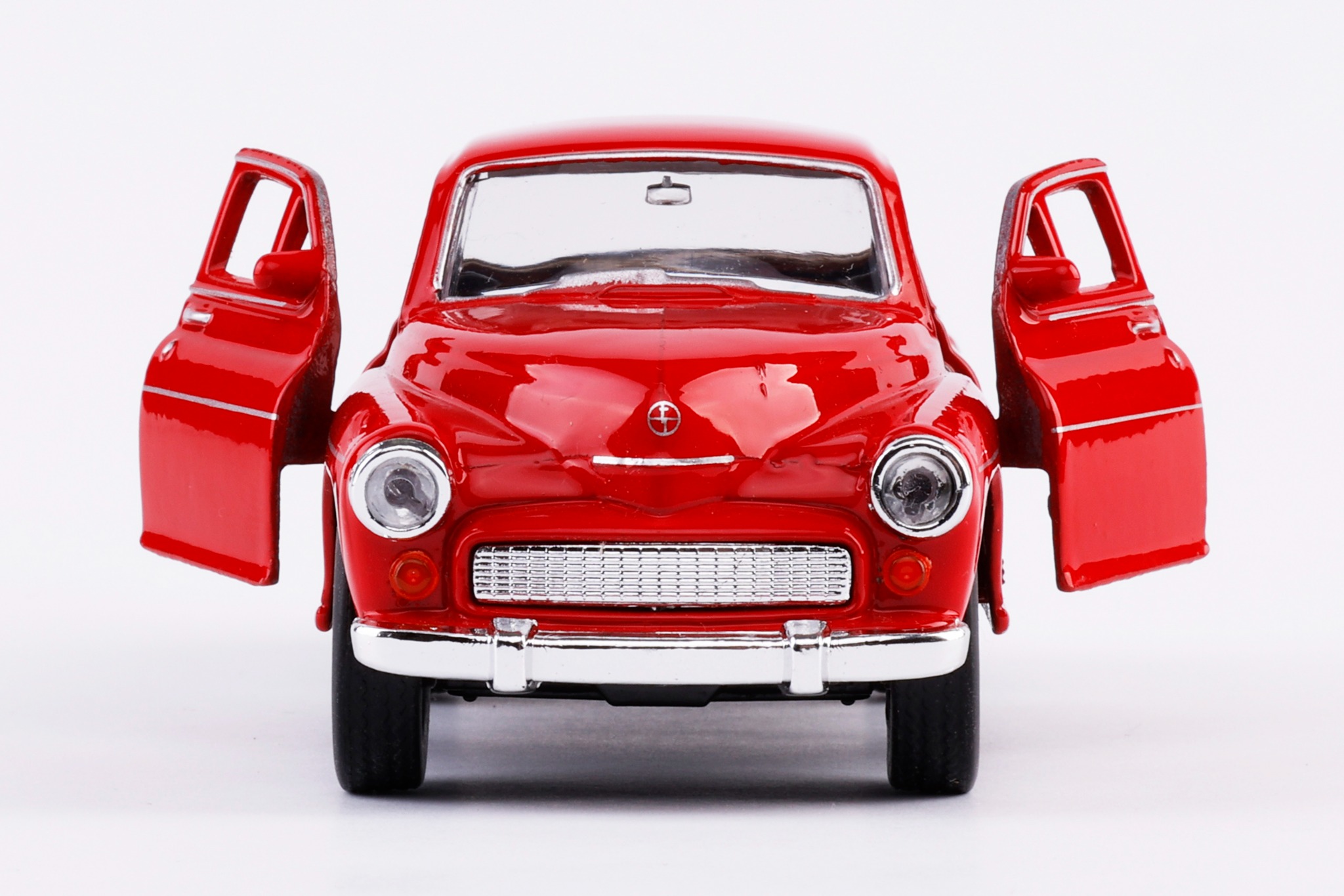 Model czerwonego samochodu osobowego z otwartymi drzwiami na białym tle, widok z przodu.
