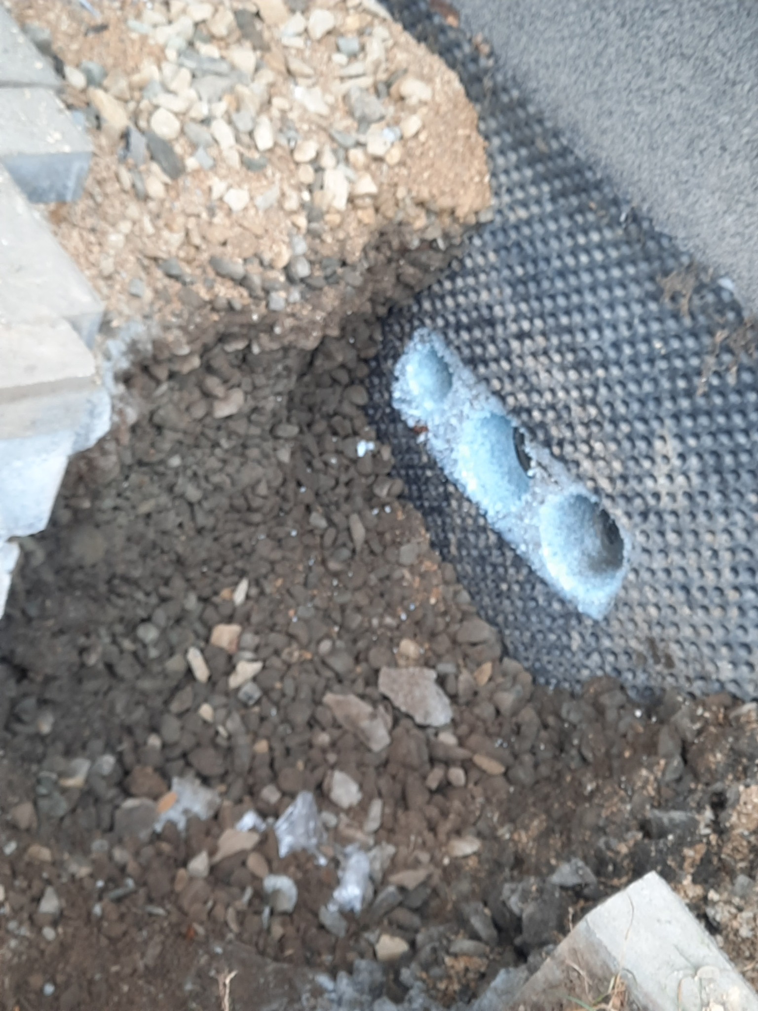 Drenaż rozsączający z rur w gruncie, zabezpieczony geowłókniną, w trakcie prac ziemnych w Bujakowie.