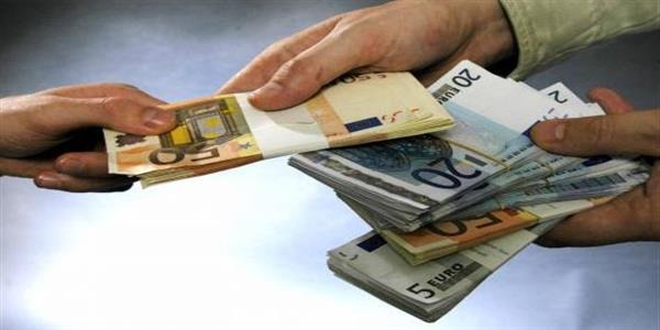 Dwie dłonie wymieniające się plikami banknotów euro o różnych nominałach: 50, 20, 10 i 5 euro, na jasnym, rozmytym tle.