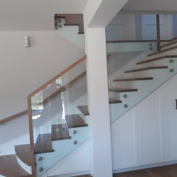 Schody na beton,drewno dąb barwiony,podstopnica oraz cokoły boczne malowane na biało,barierka szklana montowana do boku schodów z poręczą drewnianą.