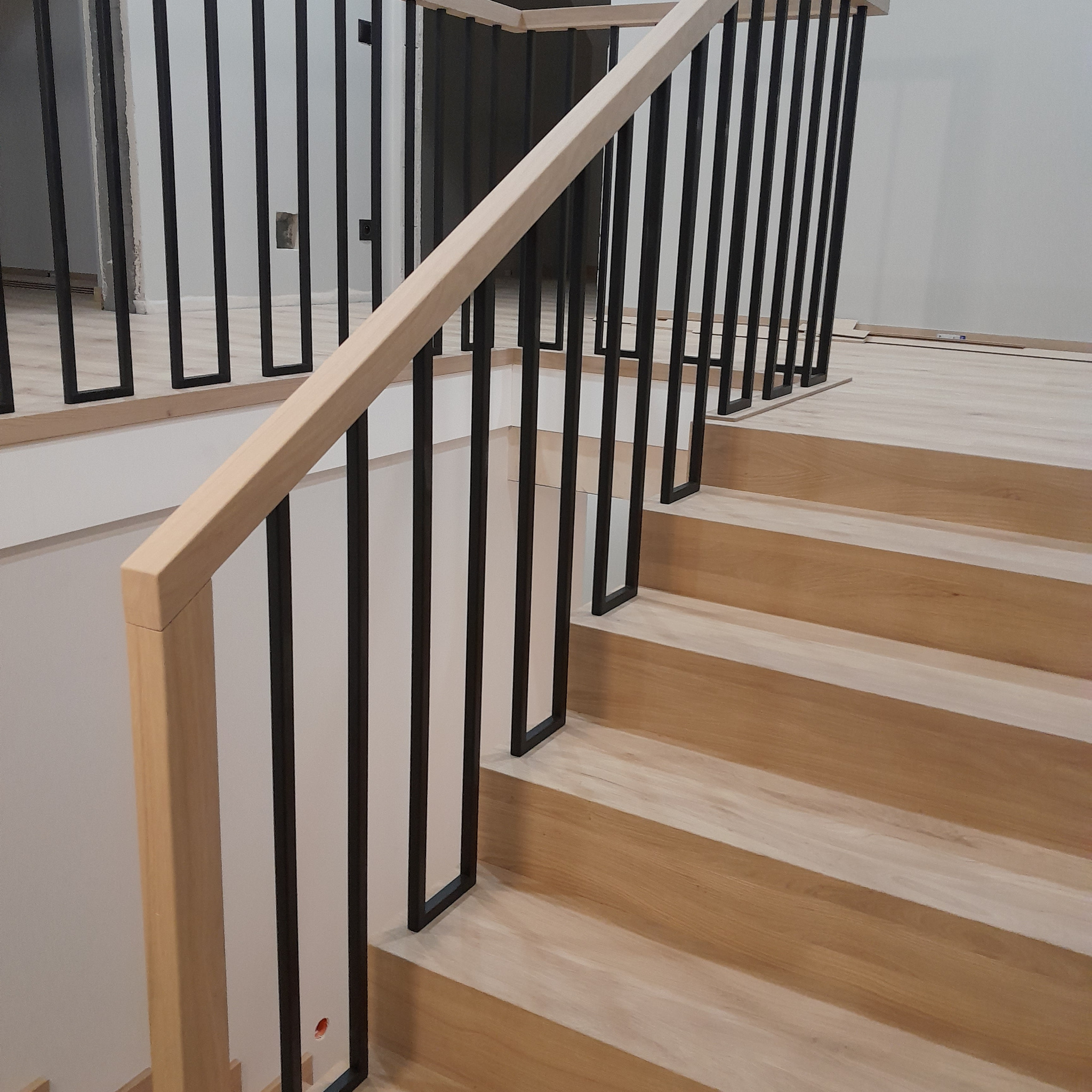 Schody na beton,drewno dąb,barierka z czarnymi stalowymi elementami.