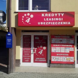 Fasada budynku z szyldem 'Kredyty, Leasingi, Ubezpieczenia Cash 4 You', widoczne logotypy różnych banków i firm ubezpieczeniowych na drzwiach i ścianie, w oknie na piętrze widoczne dzieci.