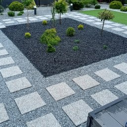 Wprowadzenie gruntownych zmian w ogrodzie, w tym położenie sztucznej trawy, wykonanie ścieżek z płyt i rabaty środkowej.