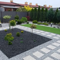 Wprowadzenie gruntownych zmian w ogrodzie, w tym położenie sztucznej trawy, wykonanie ścieżek z płyt i rabaty środkowej.