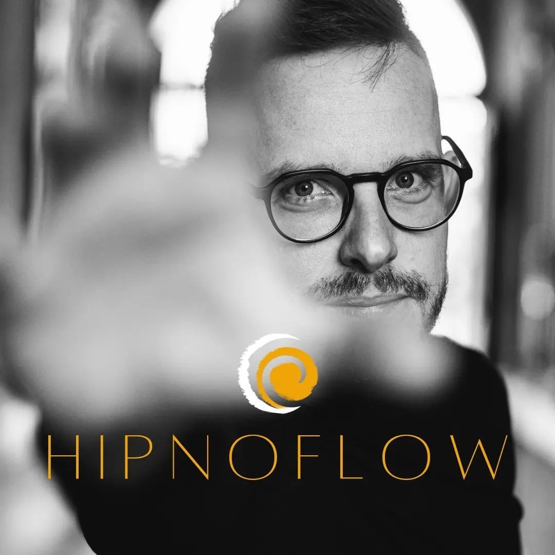 Czarno-biały portret mężczyzny w okularach, z logotypem firmy 'HIPNOFLOW' w dolnej części kadru, częściowo zasłonięty rozmytą dłonią.
