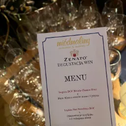 Menu degustacyjne win Zenato w restauracji Miódmaliny, z listą dań takich jak Fritto Misto i Carpaccio Cipriani, na tle kieliszków