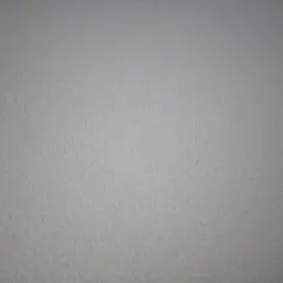 Jasnoszara, gładka powierzchnia ściany z delikatną teksturą, oświetlona naturalnym światłem, ukazująca drobne nierówności i subtelne cienie.