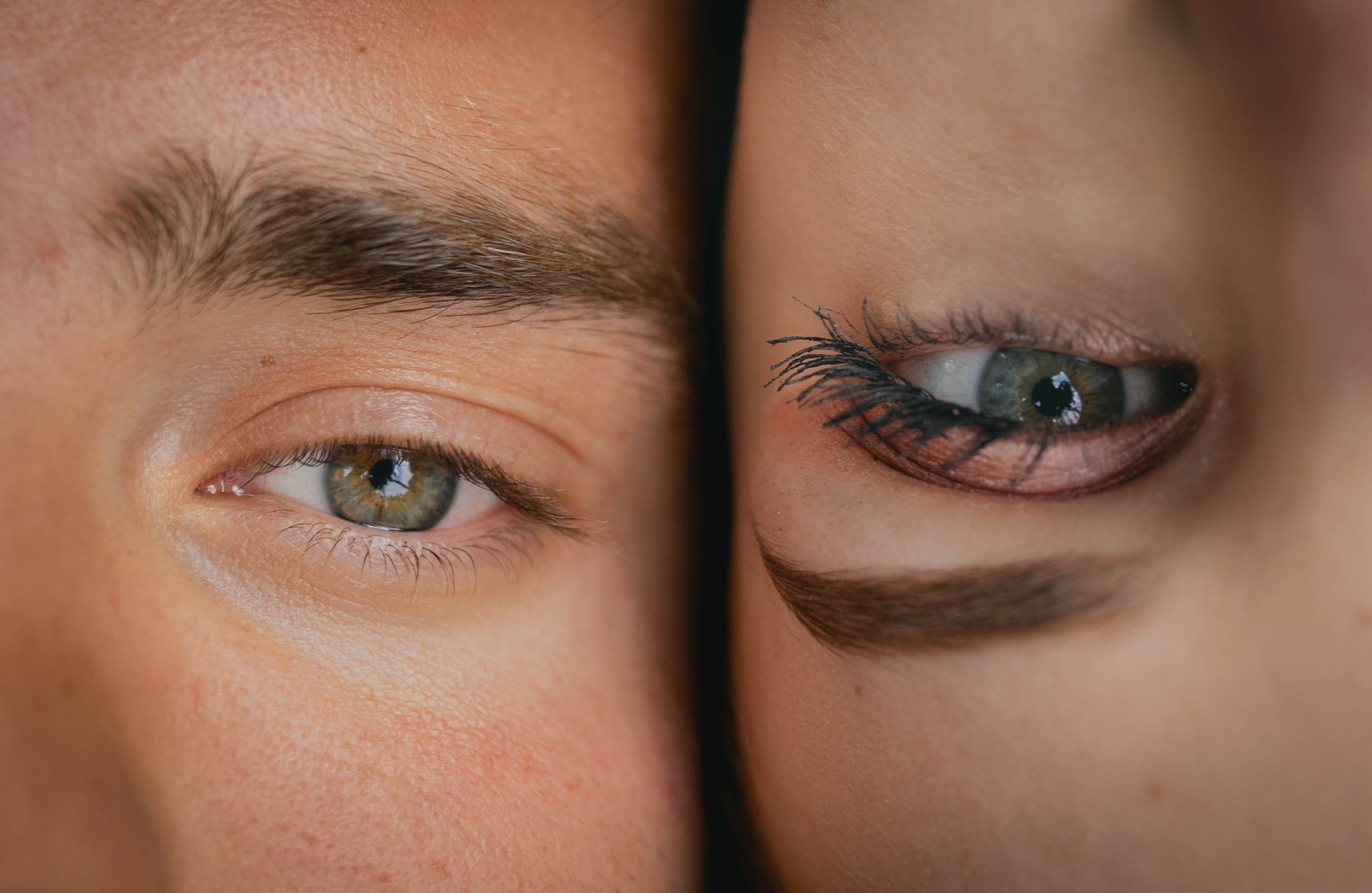 Zbliżenie na oczy pary z Łochowa: męskie oko o zielonkawo-brązowej tęczówce i kobiece oko z wyrazistym makijażem i sztucznymi rzęsami.