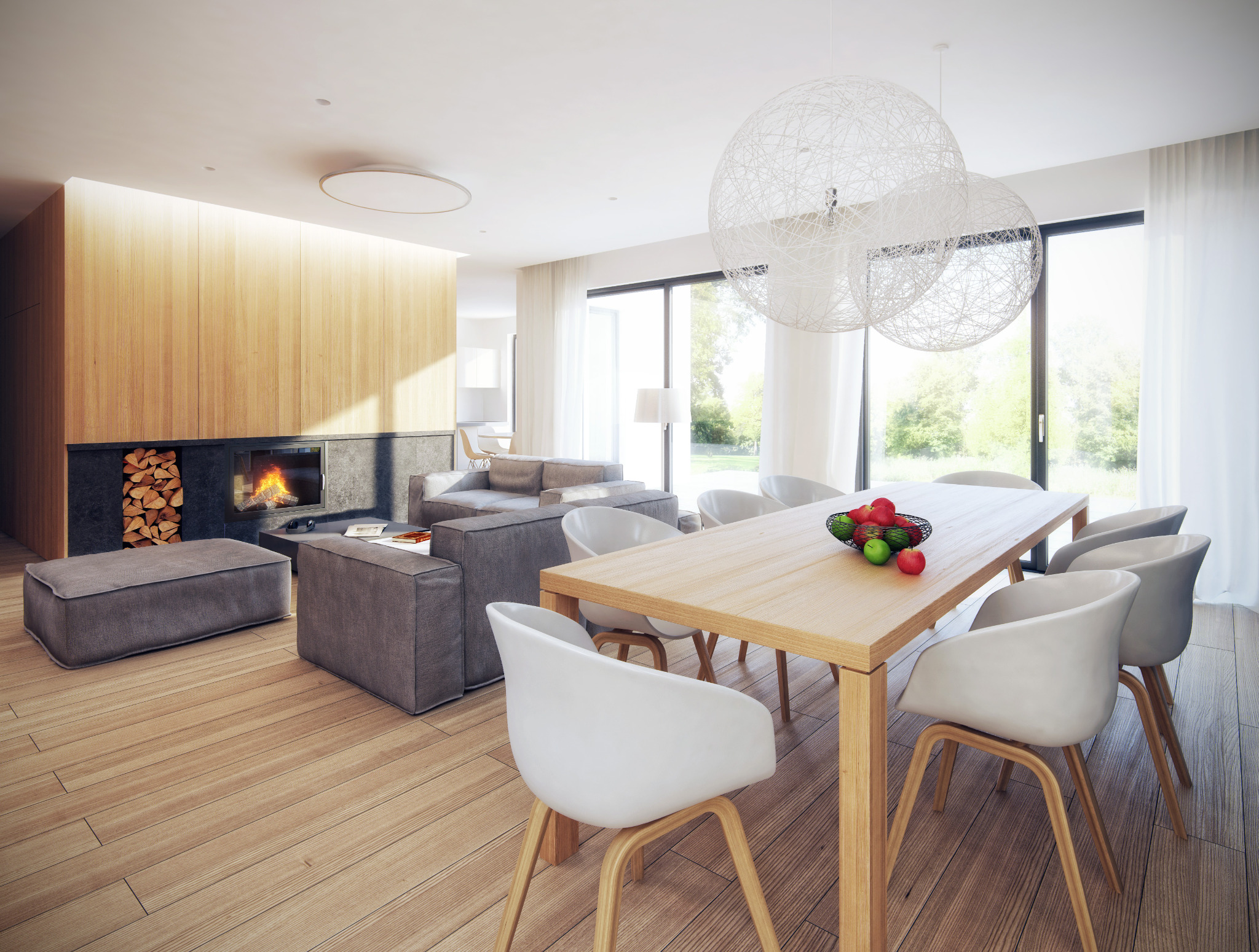 Jasne, przestronne wnętrze salonu z jadalnią, drewniana ściana z kominkiem, minimalistyczne meble, stół z owocami, wiszące lampy kuliste.