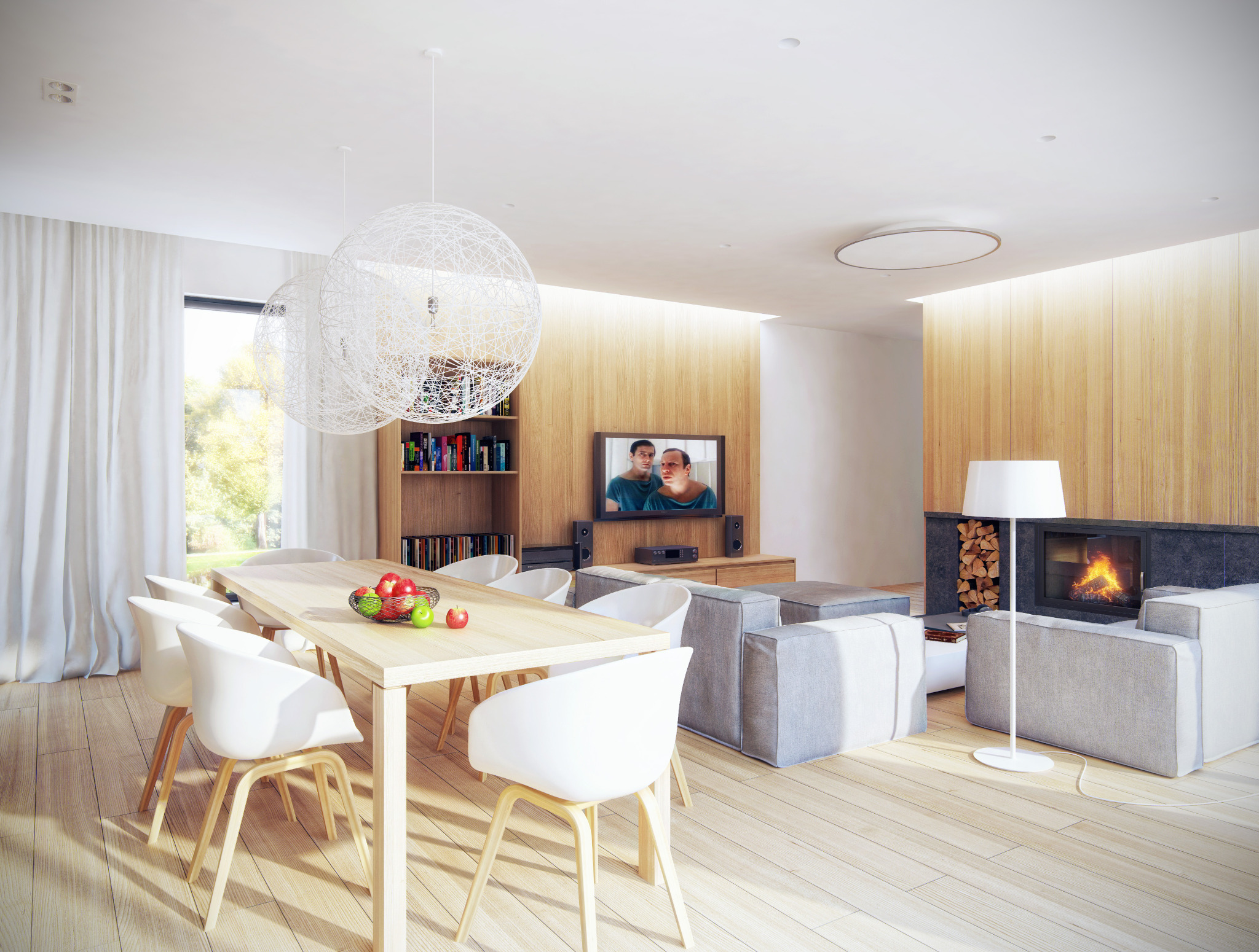 Jasne, przestronne wnętrze z jadalnią i salonem, drewniana podłoga, stół z owocami, kominek z paleniskiem, telewizor z filmem w tle, nowoczesne lampy wiszące.