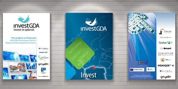 Trzy plakaty informacyjne 'InvestGDA' wiszące na ścianie z cegły, prezentujące logo, hasła i listę firm partnerskich.