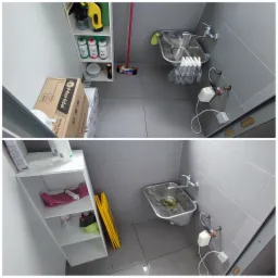 Umywalka przemysłowa ze stali nierdzewnej przed i po czyszczeniu, widoczne środki czystości na półkach i karton z papierem toaletowym, żółty znak ostrzegawczy 'uwaga ślisko' stoi obok