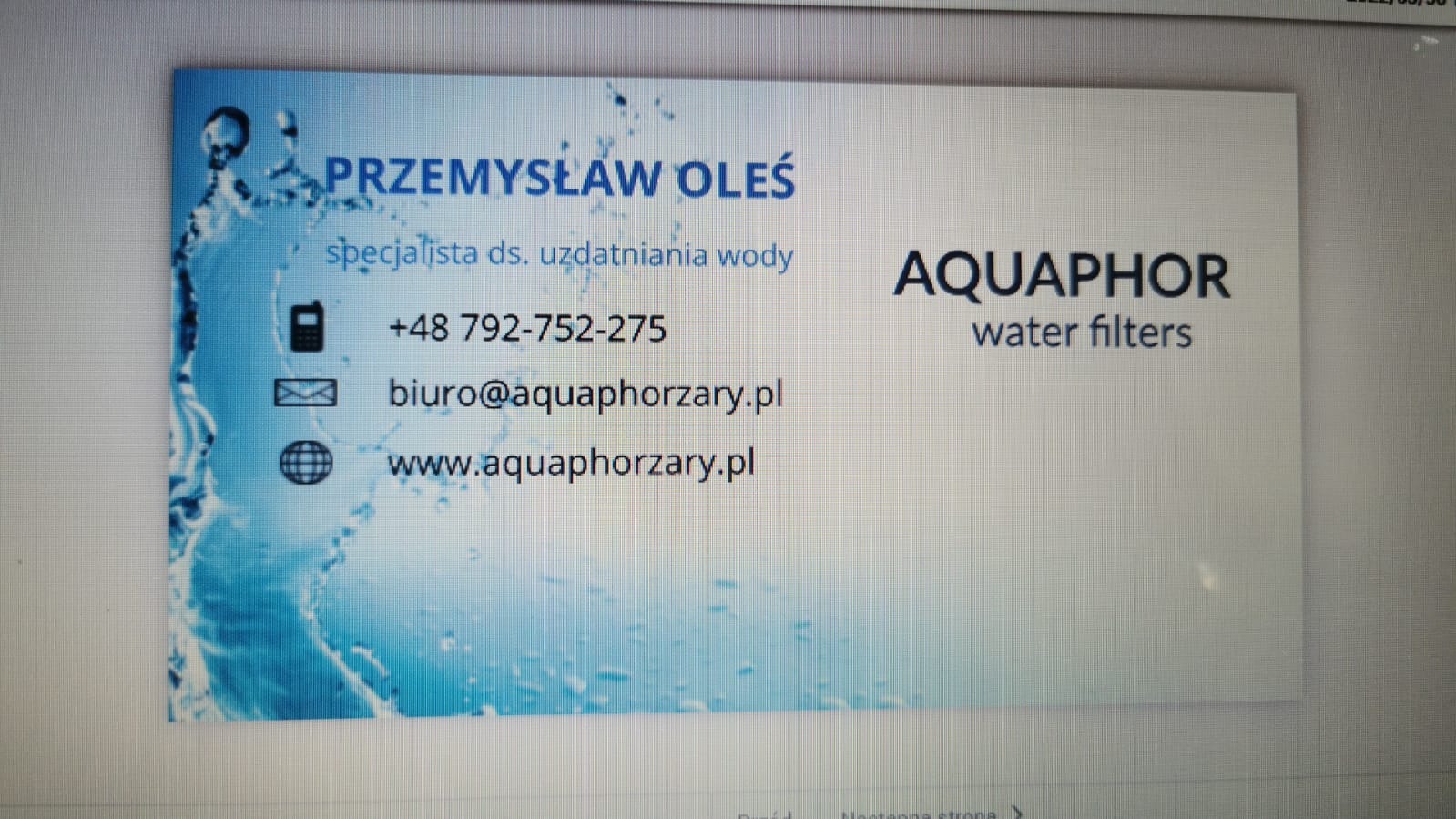 Wizytówka firmy Aquaphor, specjalisty ds. uzdatniania wody, z imieniem i nazwiskiem Przemysław Oleś oraz danymi kontaktowymi: numer telefonu, adres e-mail i strona internetowa. Tło wizytówki...