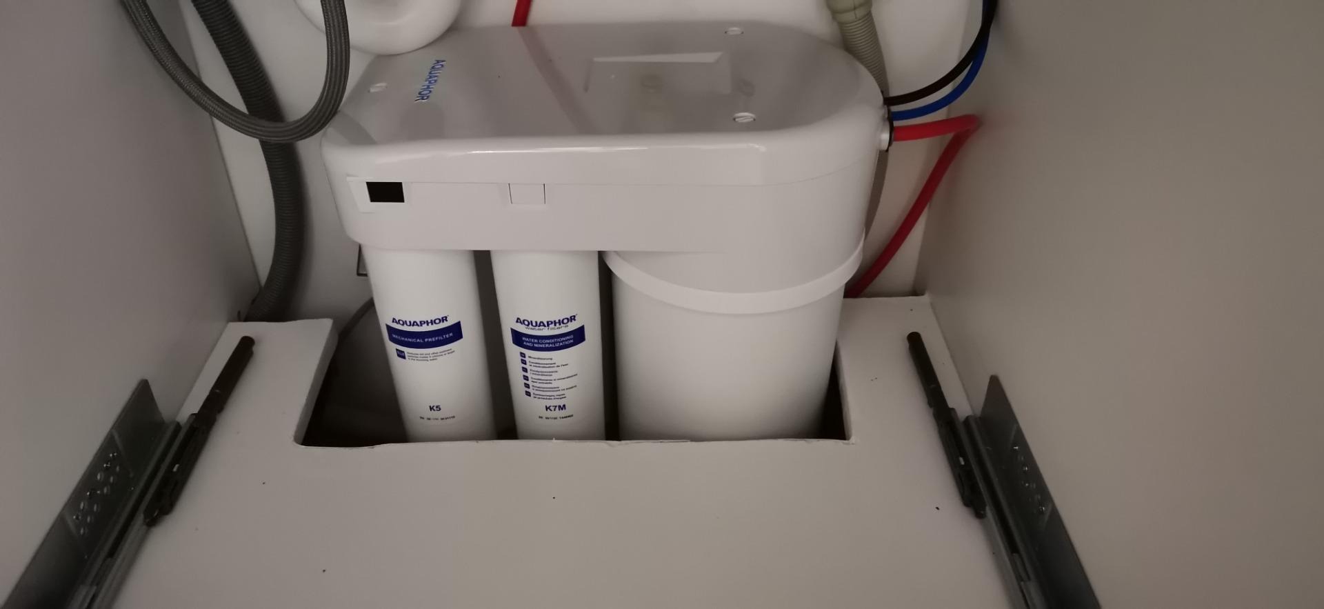 Filtr do wody Aquaphor K5 i K7M zainstalowany pod zlewem w Żarach, z widocznymi przewodami doprowadzającymi wodę.