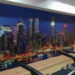 Tapeta z nocnym widokiem na panoramę Nowego Jorku, zamontowana na ścianie siłowni, widoczne bieżnie.