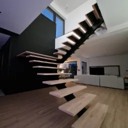 Nowoczesne, ażurowe schody drewniane z czarną konstrukcją w przestronnym wnętrzu domu w Bydlinie, widok z dołu na tle salonu.