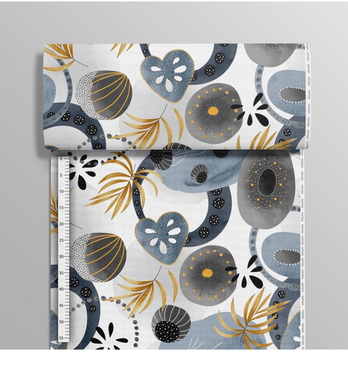 Fragment materiału z abstrakcyjnym wzorem w odcieniach szarości, błękitu i złota, zwinięty na górze, z widoczną podziałką centymetrową po lewej stronie, sugerującą pomiar.
