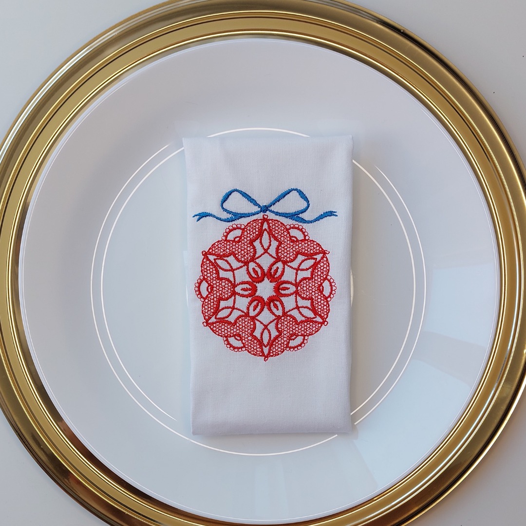czerwona, haftowana bombka na bawełnianej serwetce, zamówienie indywidualne