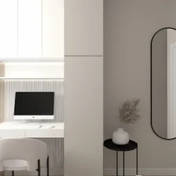 Nowoczesny gabinet w beżach: biurko z komputerem, lampka, krzesło, wysoka zabudowa meblowa, lustro w czarnej ramie, dekoracja z suszonych traw w wazonie.