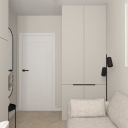 Flare Design Agata Mucha - Beżowe wnętrze z biurkiem, szafą i sofą. Minimalistyczny design z czarnymi akcentami: lampa, rama lustra, uchwyty. Na ścianie abstrakcyjny obraz w jasnej ramie.