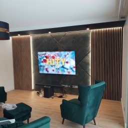 E&K BUD Krzysztof Smolarczyk - Nowoczesny salon z panelem ściennym z lameli drewnianych i zielonymi fotelami, oświetlenie punktowe nad telewizorem