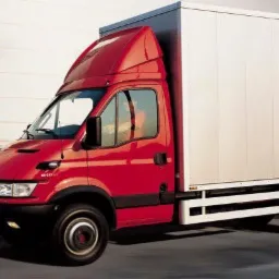 Czerwony samochód dostawczy z białą zabudową kontenerową, w ruchu, z efektem rozmycia tła, sugerującym szybką jazdę.