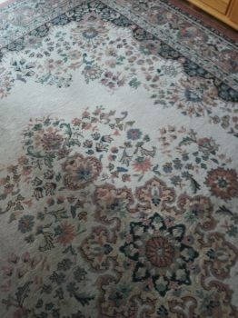 Wzorzysty dywan w odcieniach beżu i brązu z motywami kwiatowymi, widok z góry, Poznań.