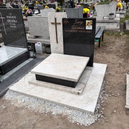 MARSTONE ANTKOWIAK BARBARA - Granitowy nagrobek z krzyżem i zdjęciem osoby zmarłej na cmentarzu. Jasny kamień z ciemnymi elementami. Widoczne inne nagrobki w tle.