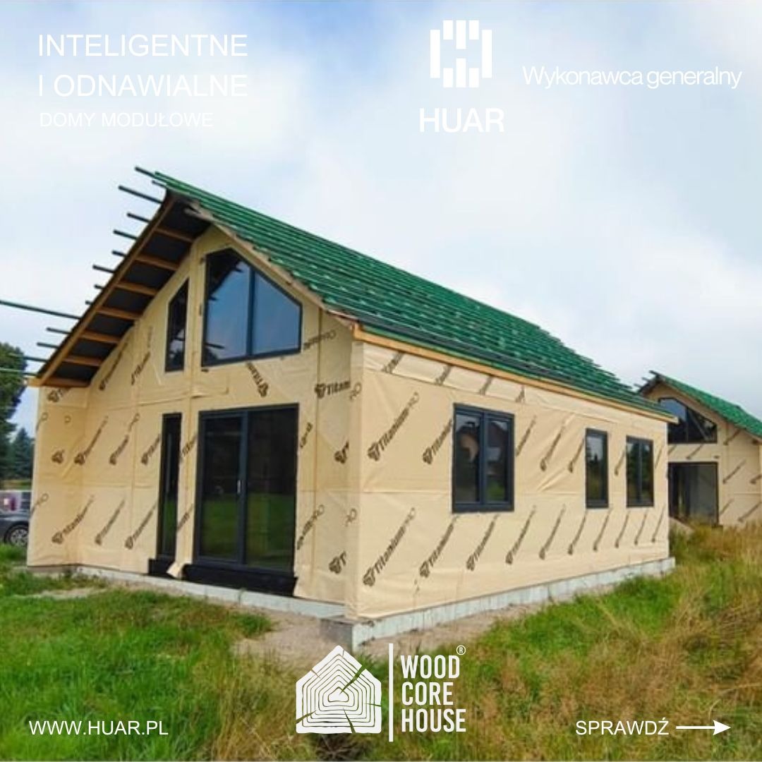 Dwa domy w trakcie budowy, pokryte membraną izolacyjną z zielonym dachem, widoczne logo firmy Wood Core House.