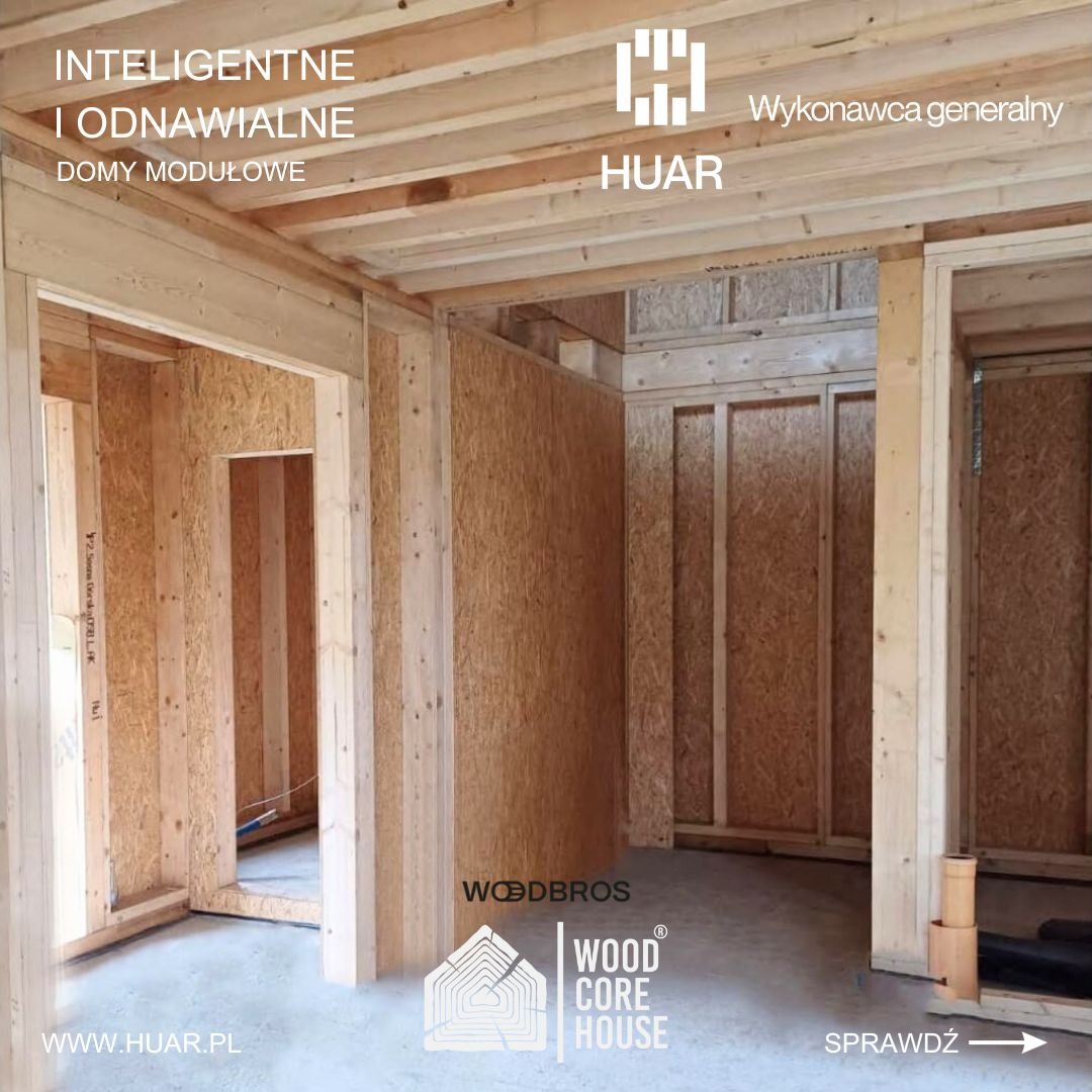 Wnętrze w stanie surowym otwartym drewnianego domu modułowego z widocznymi elementami konstrukcyjnymi ścian, stropu i podłogi, oświetlone naturalnym światłem, z logo firm HUAR i WOODBROS...