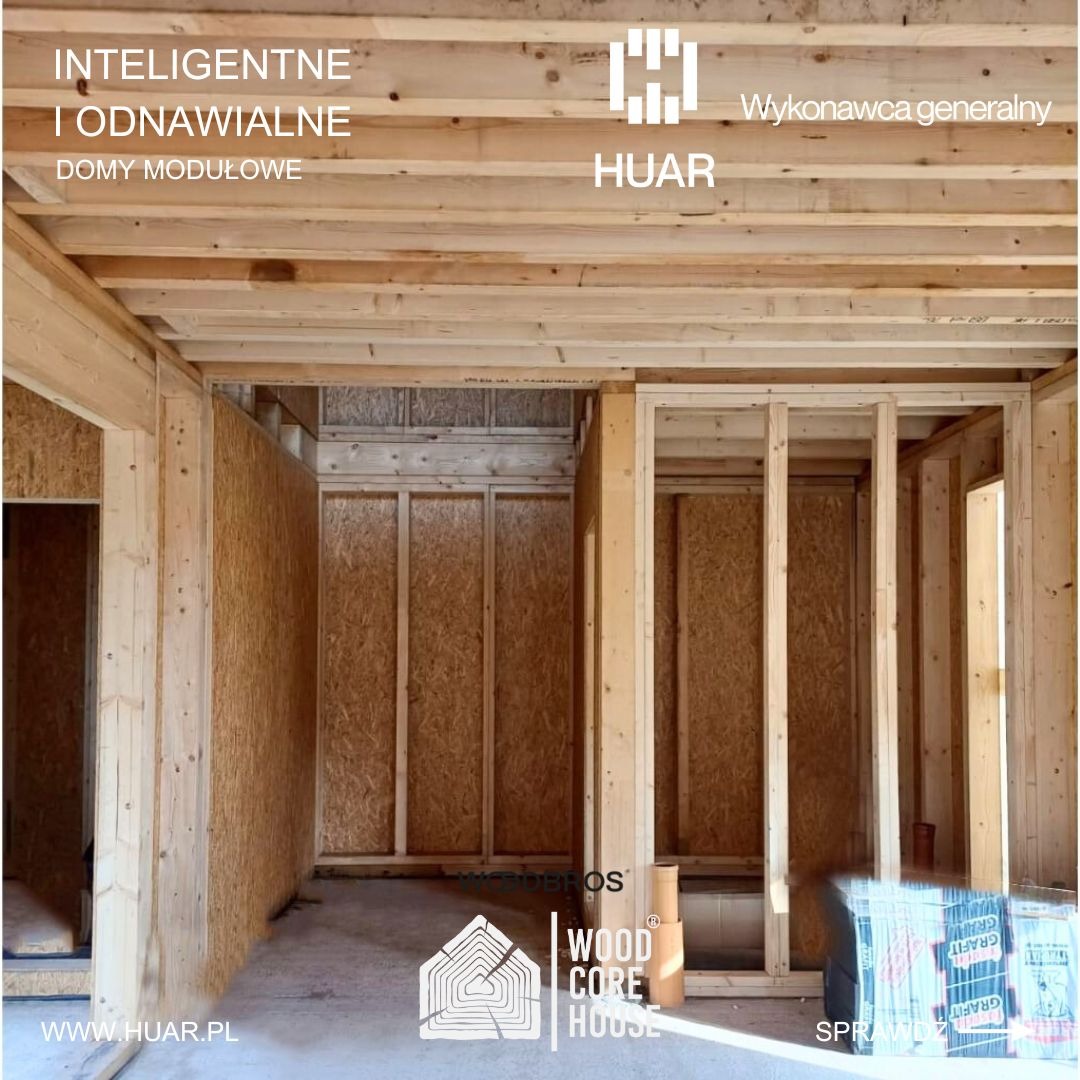Wnętrze domu modułowego w trakcie budowy, widoczne drewniane ramy ścian i stropu, płyty OSB, logo firmy HUAR oraz materiały izolacyjne GRAFIT