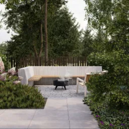 Nowoczesny ogród z betonową ławką, paleniskiem i kwitnącymi hortensjami w odcieniach bieli i różu, otoczony zielenią i drewnianym płotem.