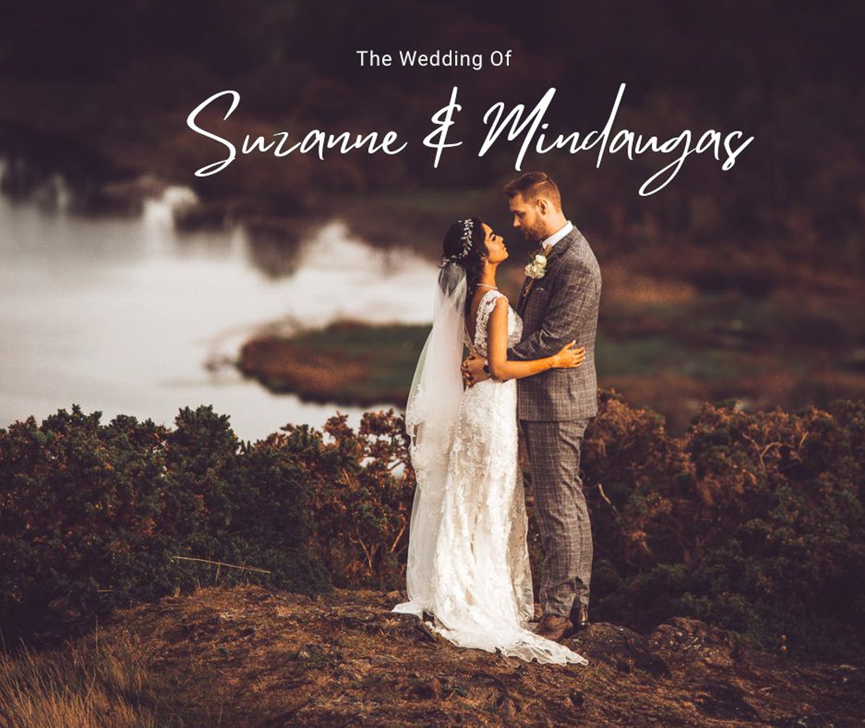 Para młoda, Suzanne i Mindaugas, w objęciach na wzgórzu z widokiem na jezioro w dniu ślubu. Panna młoda w koronkowej sukni i welonie, pan młody w tweedowym garniturze.