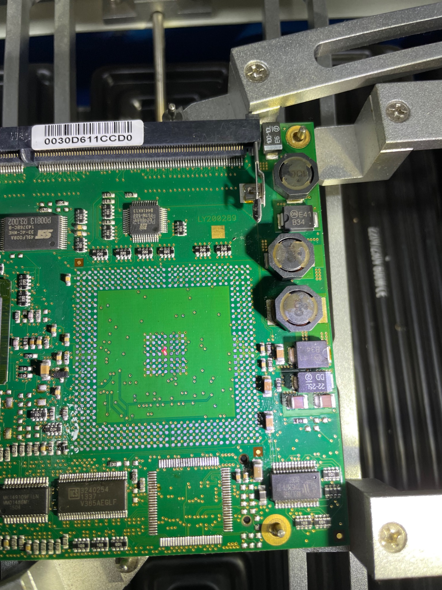 Zielona płyta główna komputera w uchwycie serwisowym we Wrocławiu, widoczne układy scalone i elementy elektroniczne poddawane inspekcji.