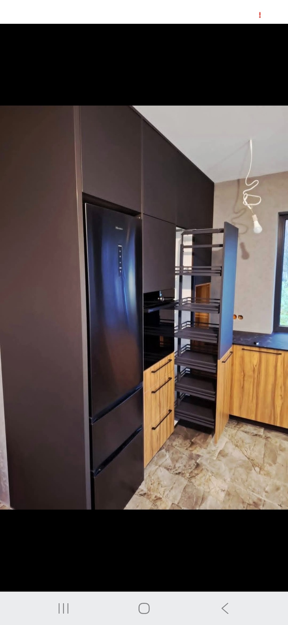 Nowoczesna kuchnia na wymiar: ciemne, matowe fronty szafek, wysuwana cargo, lodówka w zabudowie, drewnopodobne akcenty. Minimalistyczny design, funkcjonalność.