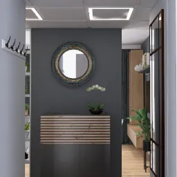 Wnętrze przedpokoju w odcieniach szarości z okrągłym lustrem w ozdobnej ramie, komodą z drewnianymi akcentami i storczykiem w czarnej doniczce, widok z perspektywy wejścia.