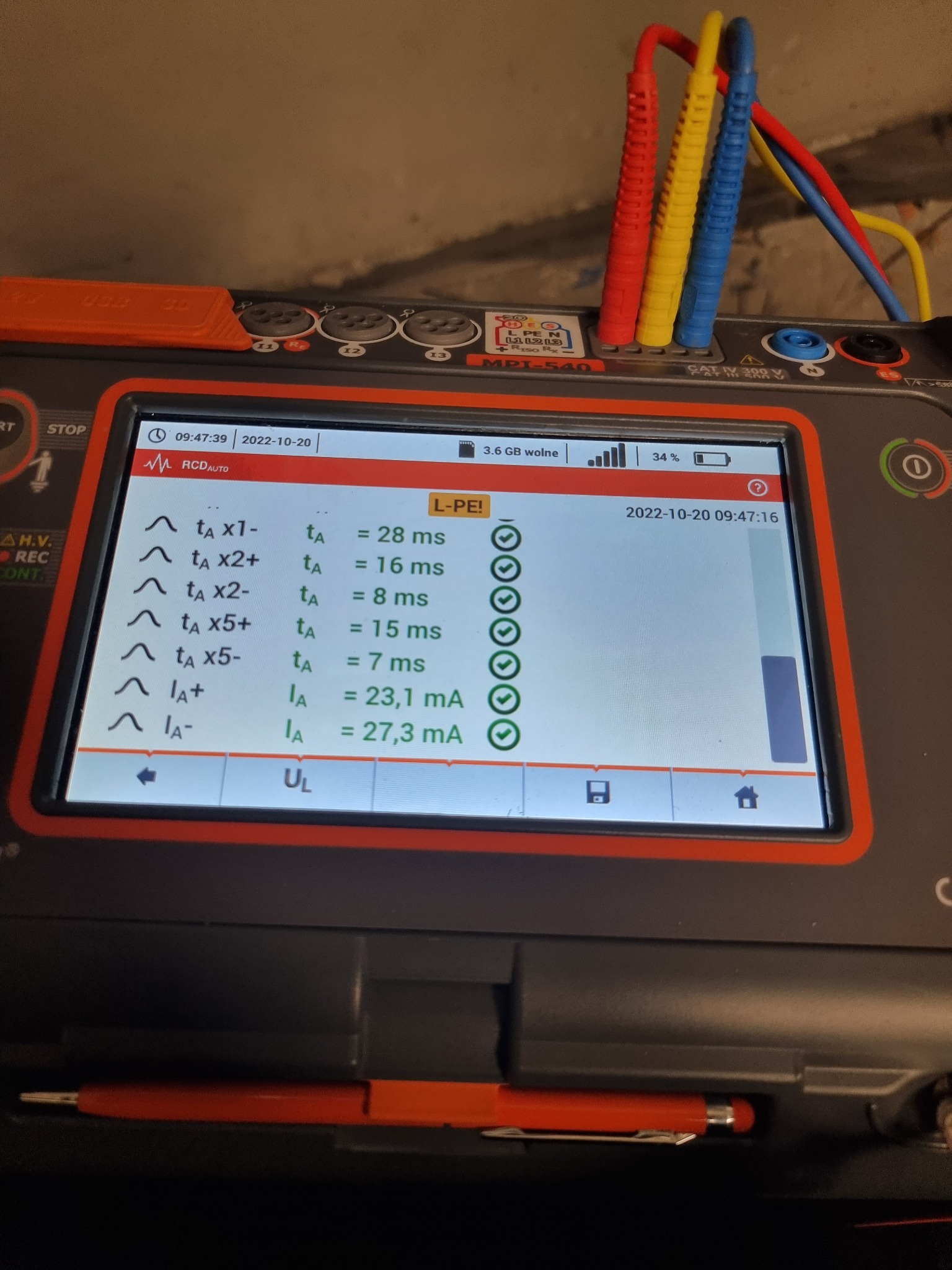 Miernik elektryczny MPI-540 z kolorowymi przewodami pomiarowymi (czerwony, żółty, niebieski) wyświetlający wyniki pomiarów parametrów RCD, w tym czasy zadziałania i prądy wyzwalania.