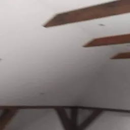 Poddasze w Piasecznie po ociepleniu, widoczne drewniane belki stropowe i okno dachowe, ściany wykończone na biało.