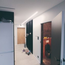 Rem Kompleks - Wnętrze mieszkania w trakcie prac wykończeniowych, widoczna łazienka z elementami drewna i marmuru, na podłodze rozsypane narzędzia i akcesoria.