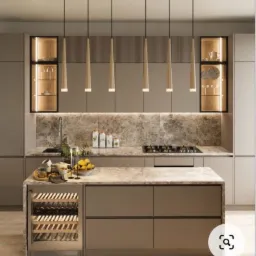 Nowoczesna kuchnia w odcieniach beżu z wyspą kuchenną, blatem z marmurkowym wzorem, oświetleniem punktowym i wbudowaną chłodziarką na wino.