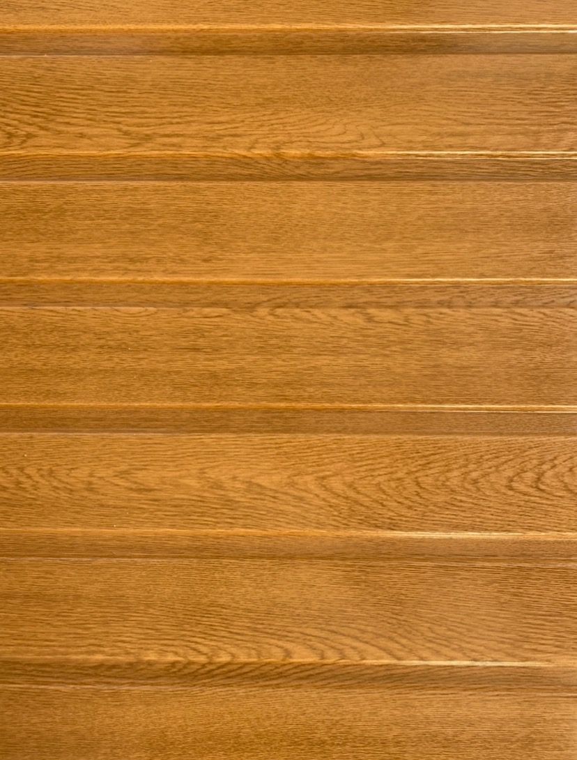 Zbliżenie na panel z blachy profilowanej o fakturze drewna w odcieniach brązu i beżu.