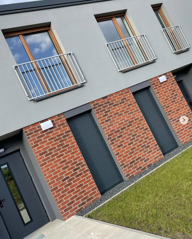 Okna PCV z roletami podtynkowymi oraz drzwi zewnętrzne z przeszkleniem reflex grafit