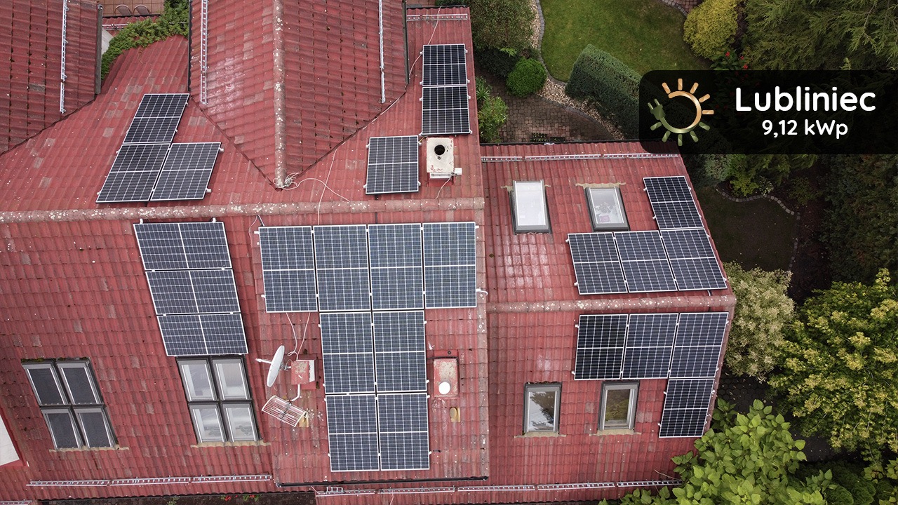 Widok z góry na dach domu z czerwonej dachówki, na którym zamontowano panele słoneczne; widoczny również ogród i logo firmy z informacją o mocy instalacji 9,12 kWp w Lublińcu.