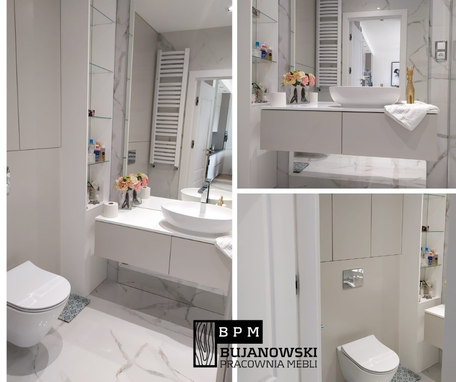 Nowoczesna łazienka z białymi meblami na wymiar, umywalką nablatową i lustrem na ścianie z marmurowym wzorem, uzupełniona o dekoracyjne akcenty i logo firmy meblarskiej w rogu.