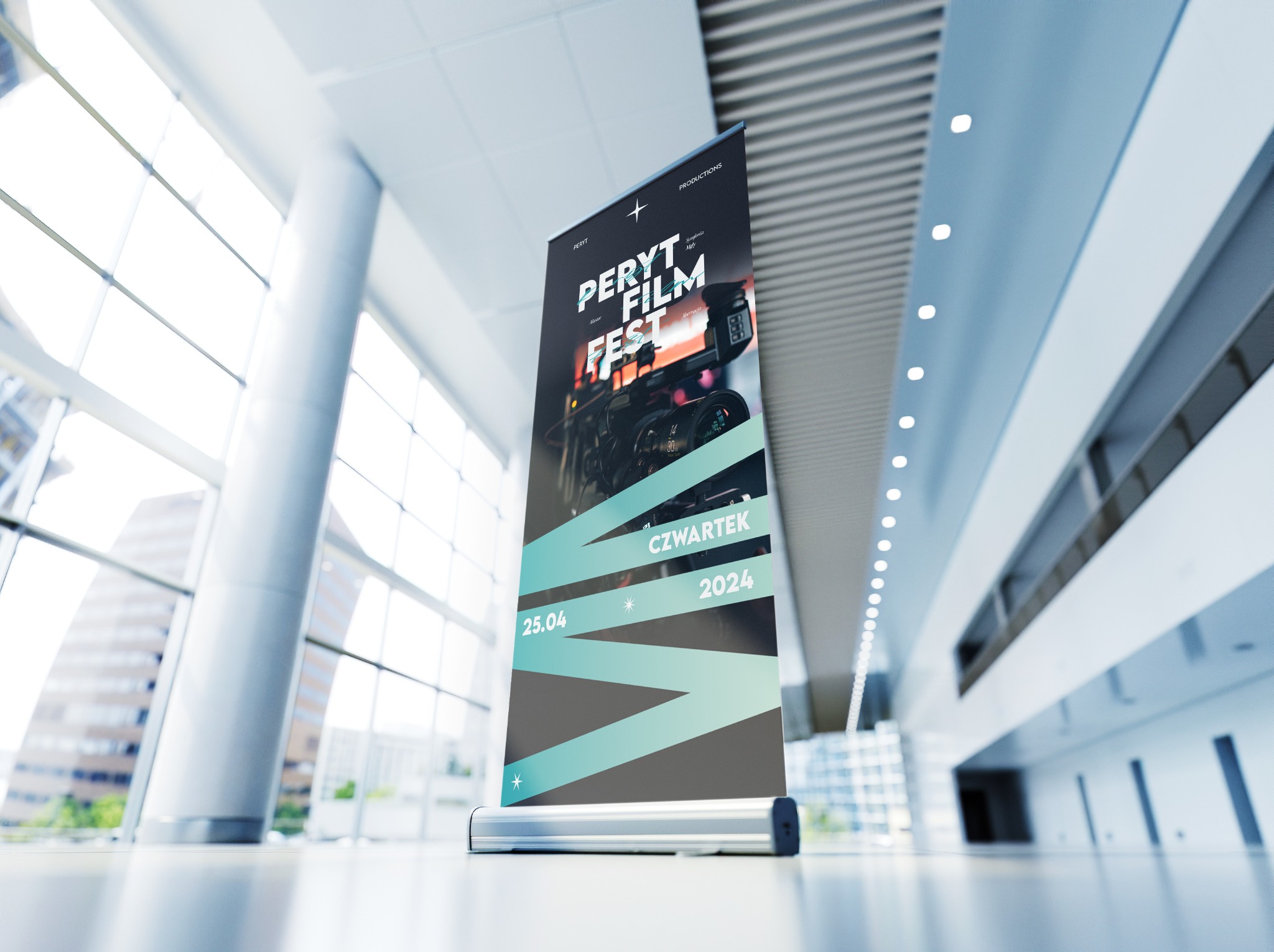 Roll-up reklamowy z grafiką festiwalu filmowego 'Peryt Film Fest' w nowoczesnym, przestronnym wnętrzu z dużymi oknami.