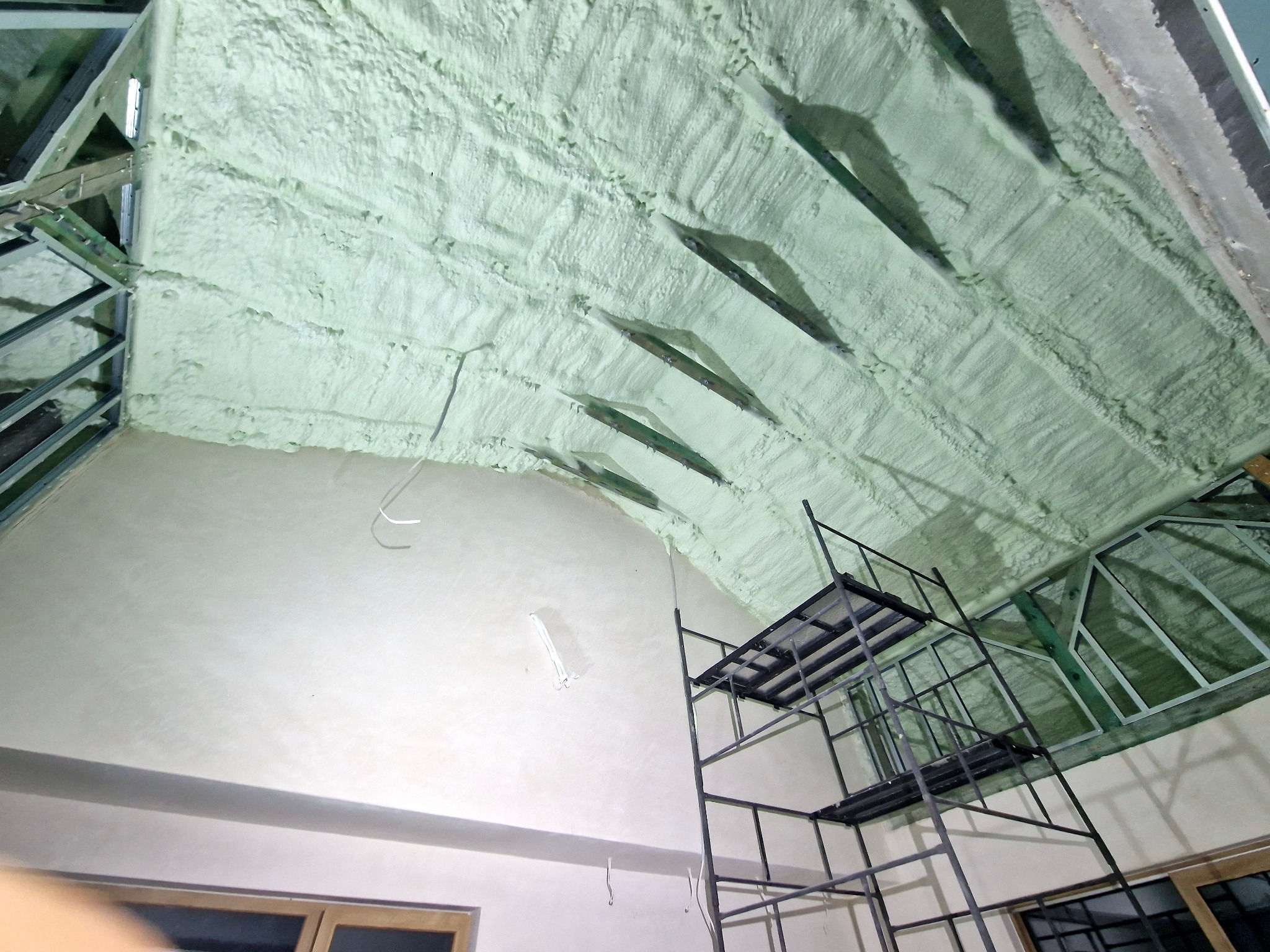 Poddasze ocieplone pianką PUR, widoczny metalowy stelaż konstrukcyjny i rusztowanie.