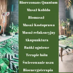 Wnętrze gabinetu z motywami roślinnymi: stół do zabiegów z zielonym pokrowcem w tropikalne wzory, stolik kawowy z zielonymi krzesłami, lampa na podczerwień i dekoracje roślinne.