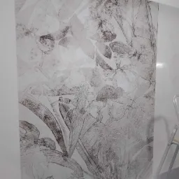 Ściana pokryta tapetą z motywem roślinnym w odcieniach szarości, widoczna drabina malarska w rogu.